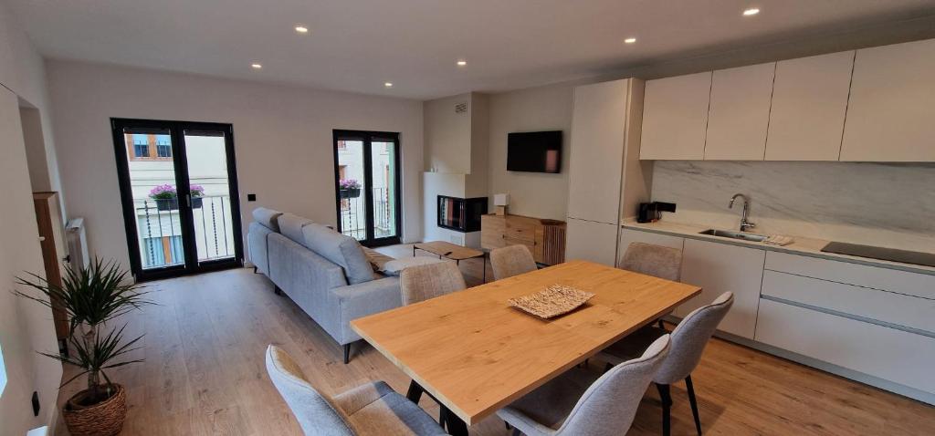 een keuken en een woonkamer met een houten tafel en stoelen bij Apartaments El Trèvol in Camprodon