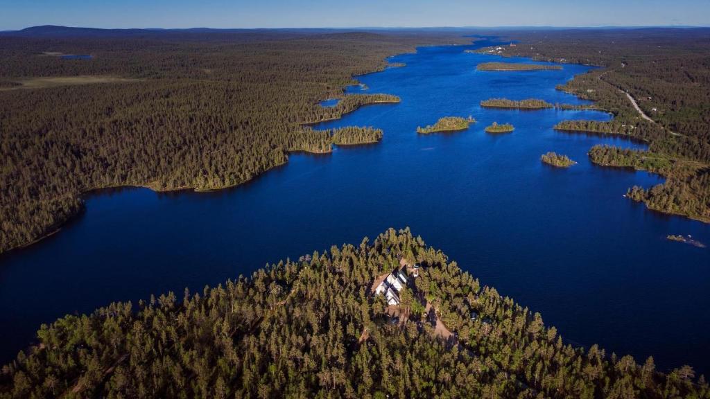 an island in the middle of a lake with trees at Arctic Lodge Hetan Kota in Enontekiö