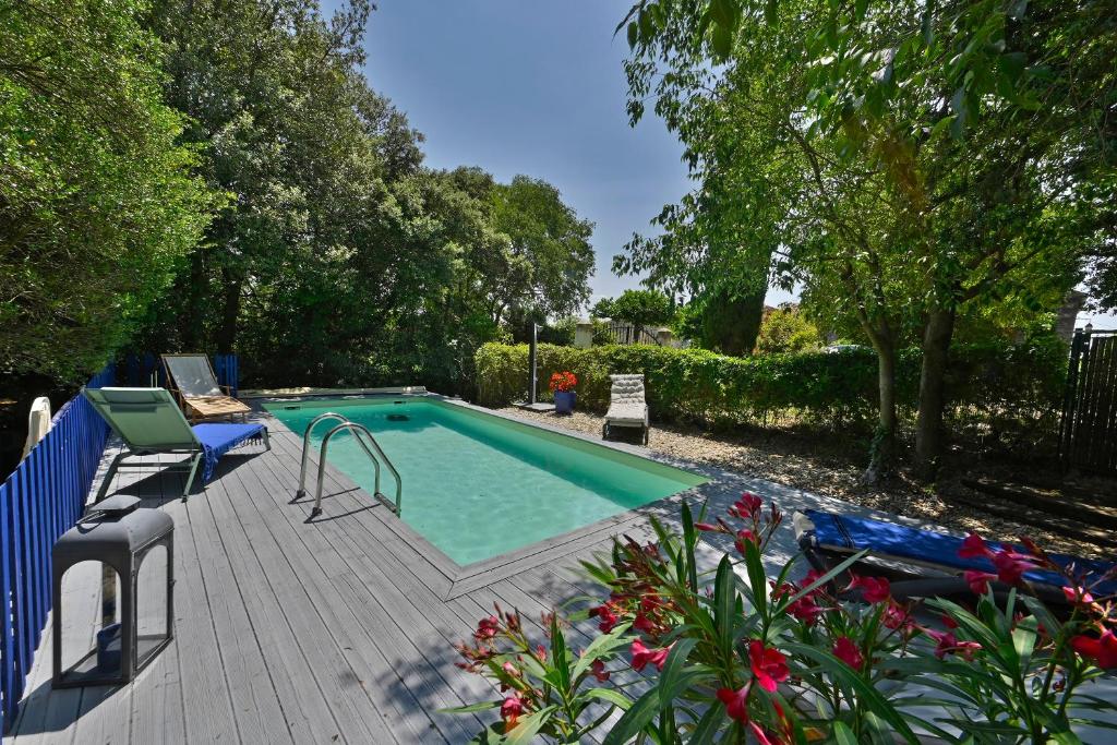 a swimming pool on a wooden deck next to at Gîte Pina - Gîte avec piscine partagée in Lussan