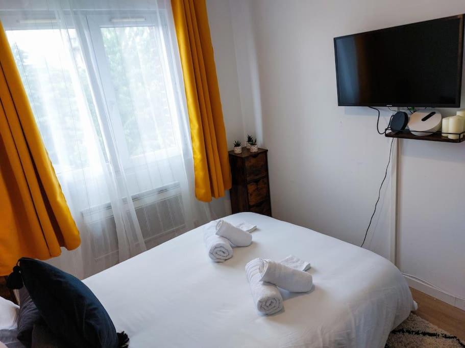 a bedroom with a white bed with towels on it at Le Sympathique - Petit Déjeuner, Netflix, Jacuzzi in Rouen