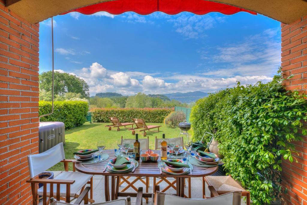 - une table et des chaises sur une terrasse avec vue dans l'établissement Miralago Lake View Outside Whirlpool - Happy Rentals, à Ispra