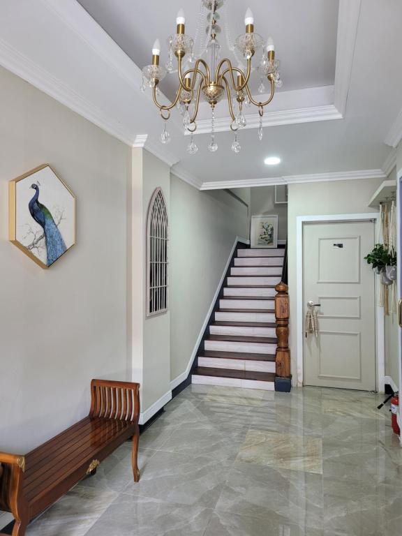 a living room with a chandelier and a staircase at Son-Gil Guesthouse in Jinju