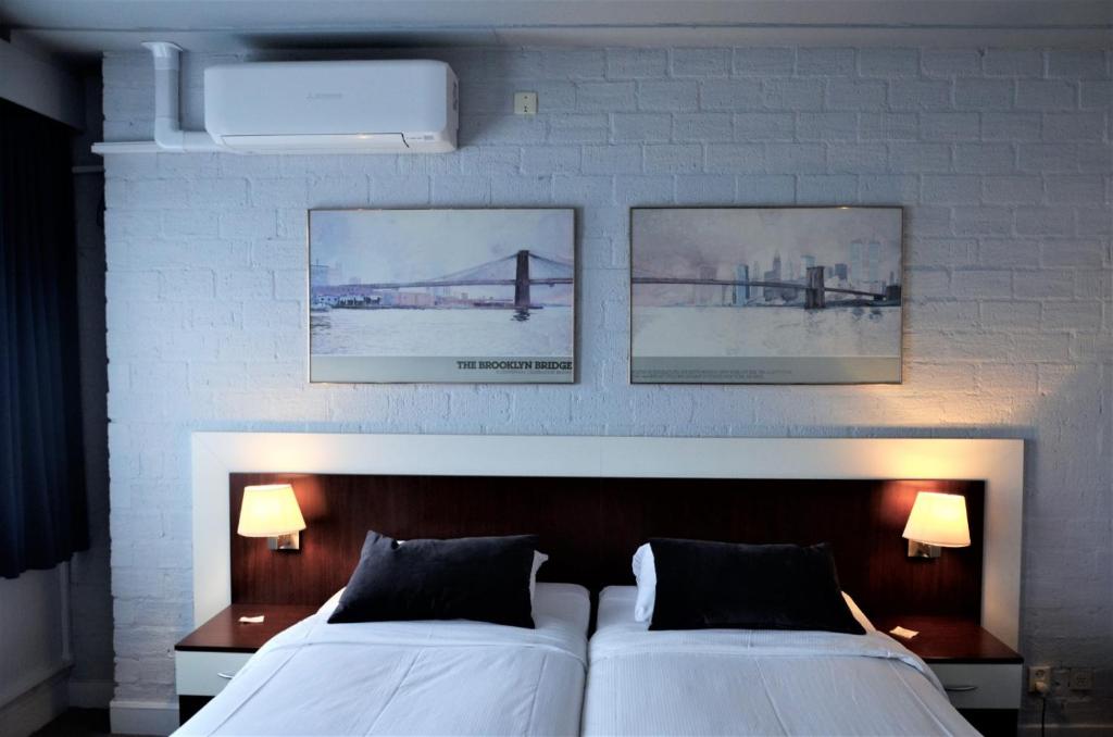 2 camas en un dormitorio con 2 cuadros en la pared en Apollo Hotel en Nijmegen