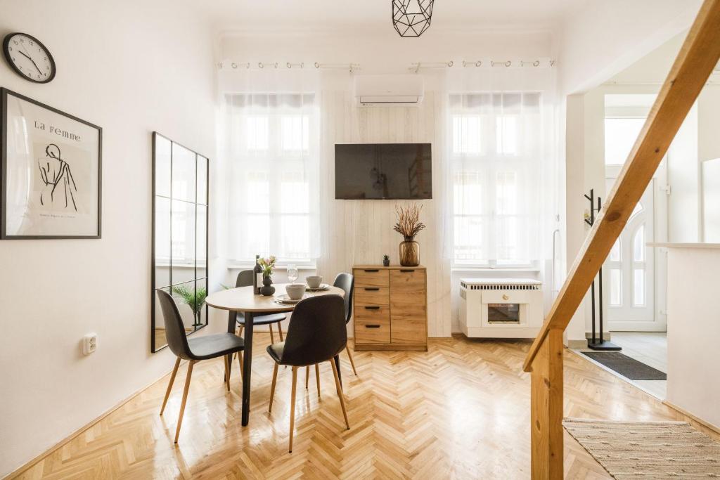 a white living room with a table and chairs at Balint Budapest Apartment next to Synagogue, best location in city center in Budapest