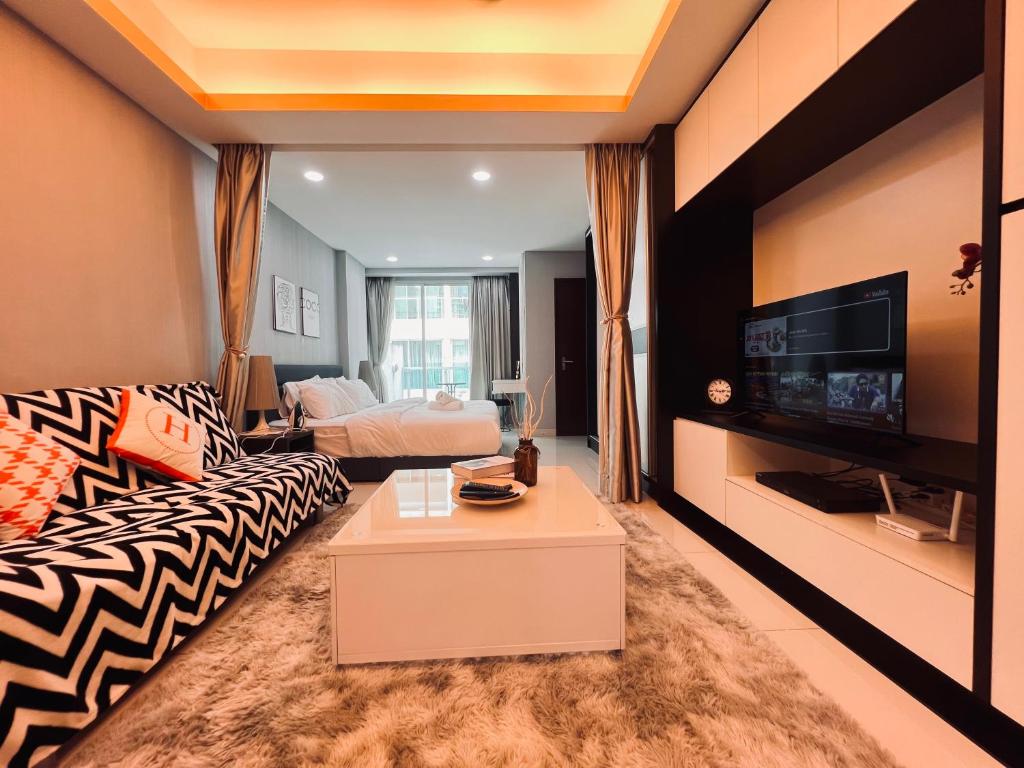 Mont kiara 5-Star Deluxe Suite 2-4pax في كوالالمبور: غرفة معيشة مع أريكة وتلفزيون
