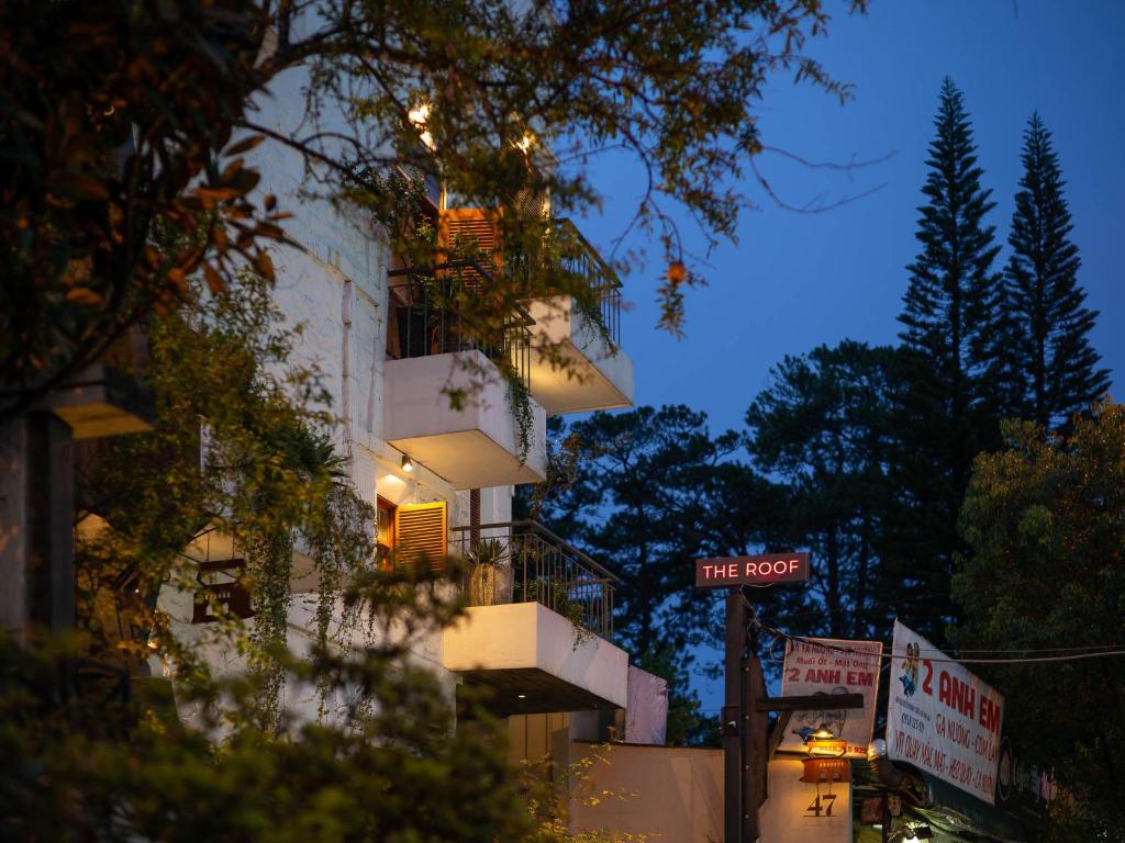 a tall white building with a balcony at night at Banla Boutique Hotel in Da Lat