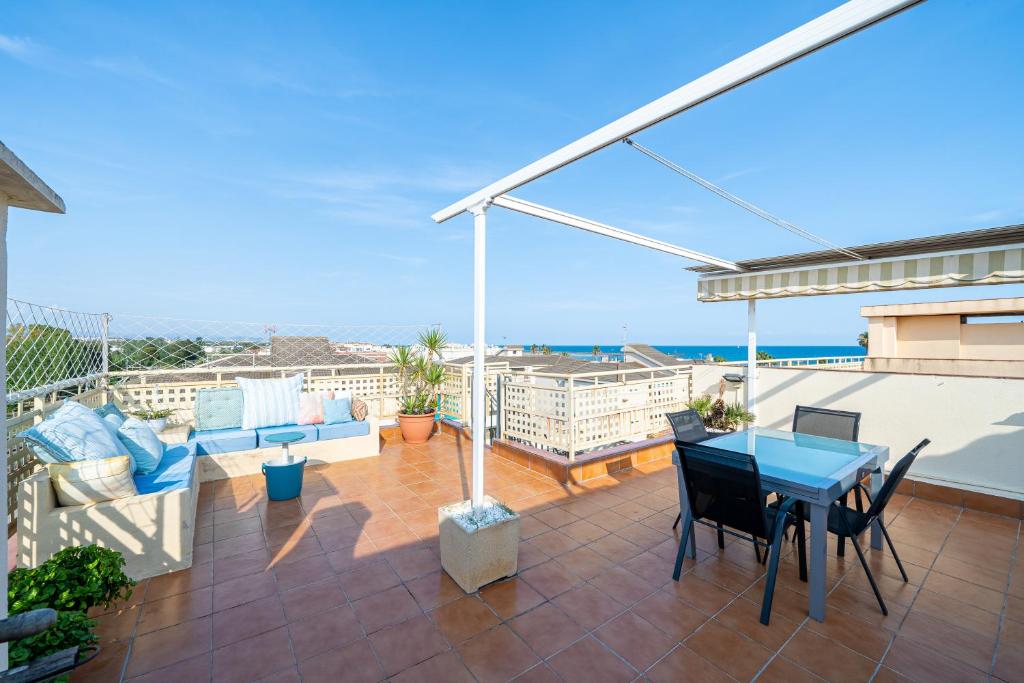 a patio with a table and chairs on a balcony at Atico Duplex Pepe y Rosi in Cunit