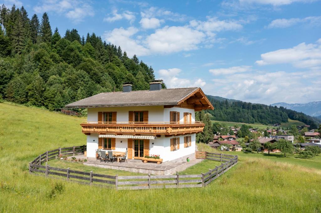 une petite maison sur une colline dans un champ dans l'établissement Landhaus Geig, à Hopfgarten im Brixental
