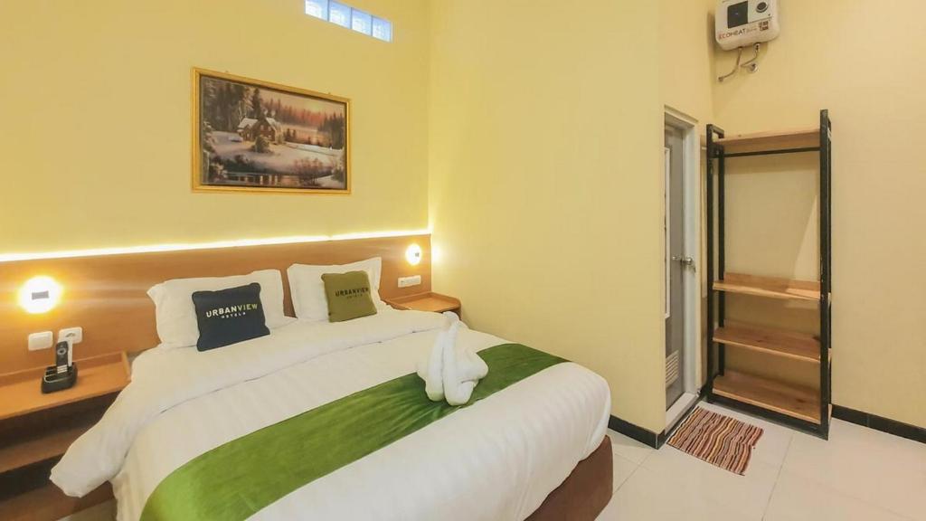 een slaapkamer met een groot wit bed in een kamer bij Urbanview Hotel Sakura Kampung Inggris Pare by RedDoorz in Pare