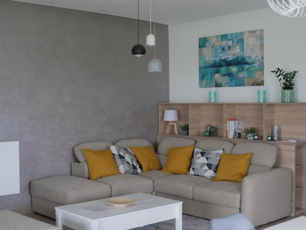 uma sala de estar com um sofá com almofadas amarelas em ADELINA Apartman 