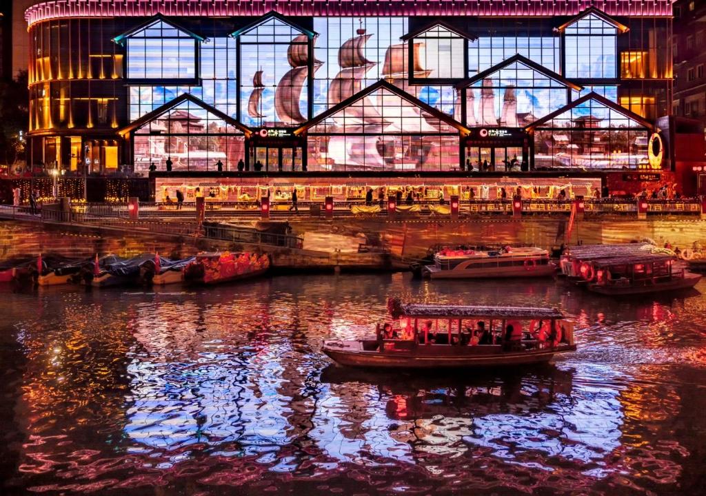 a boat in a river in front of a building at Crowne Plaza Chengdu City Center by IHG in Chengdu
