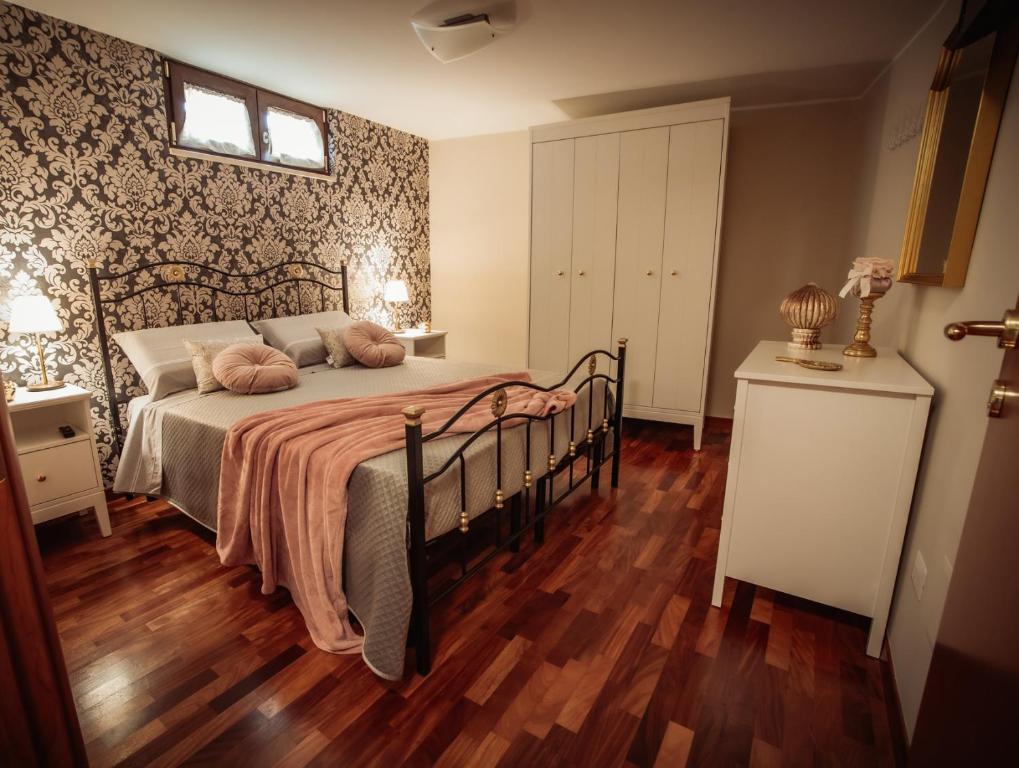 una camera da letto con un letto con cuscini rosa di LA TERRAZZA DEI GEMELLI - casa vacanze a Venosa