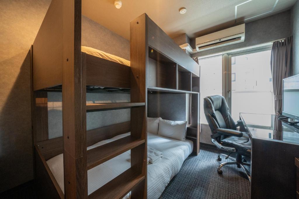 札幌的住宿－Residence Hotel Stripe Sapporo，一间卧室配有双层床和一张书桌。