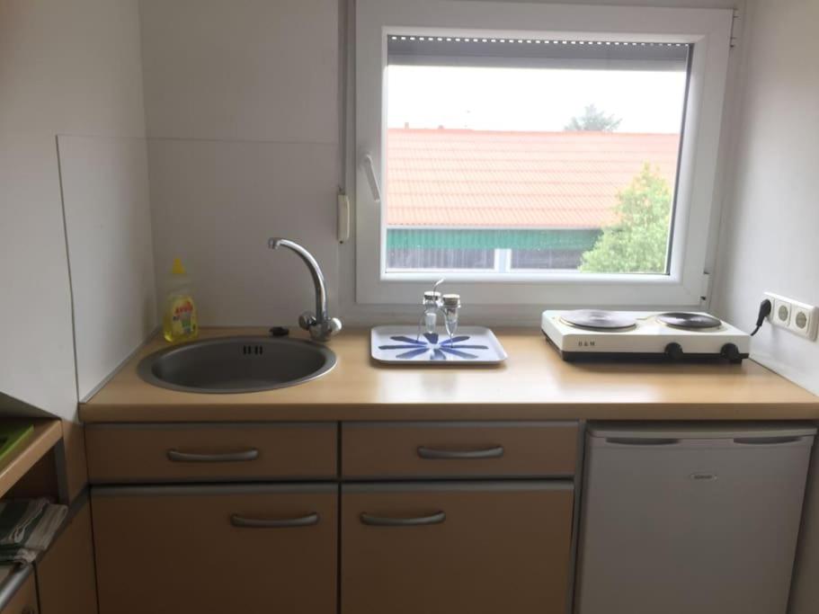 a kitchen counter with a sink and a window at Gemütliche 2 Zimmerwohnung mit tollem Ausblick in Calden