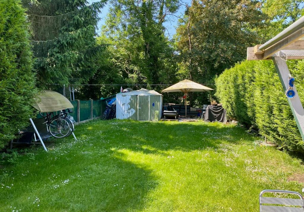 einen Garten mit grünem Rasen und Sonnenschirm in der Unterkunft Perk25A in Steenokkerzeel