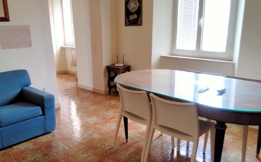 uma sala de jantar com uma mesa e um sofá azul em ATTICO SULLA BOUGANVILLE (Albergo diffuso) em Corinaldo