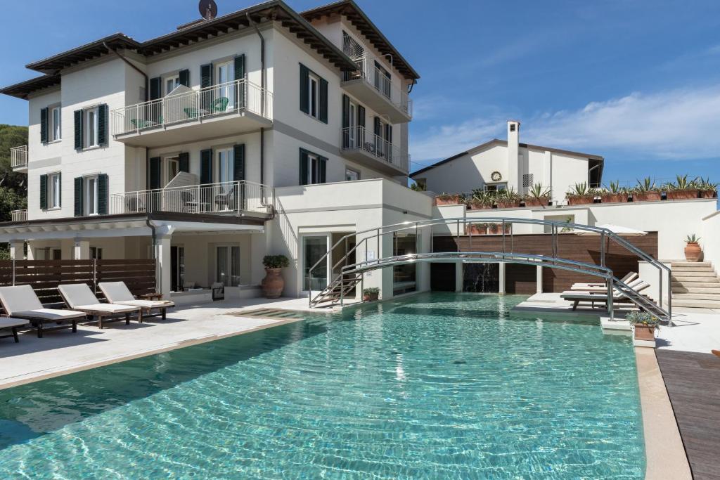 a large swimming pool in front of a building at Villa Martini in Castiglioncello