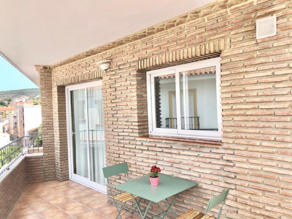 a brick wall with a table and chairs on a balcony at Alhattic in Alhaurín el Grande