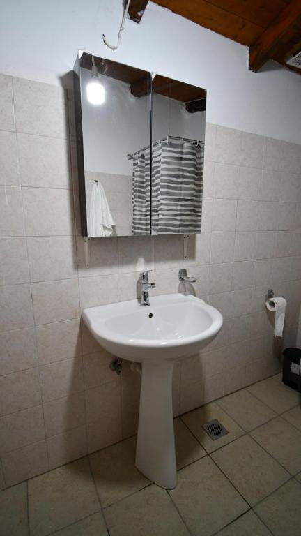 W łazience znajduje się biała umywalka i lustro. w obiekcie Anastasios House w Koroni