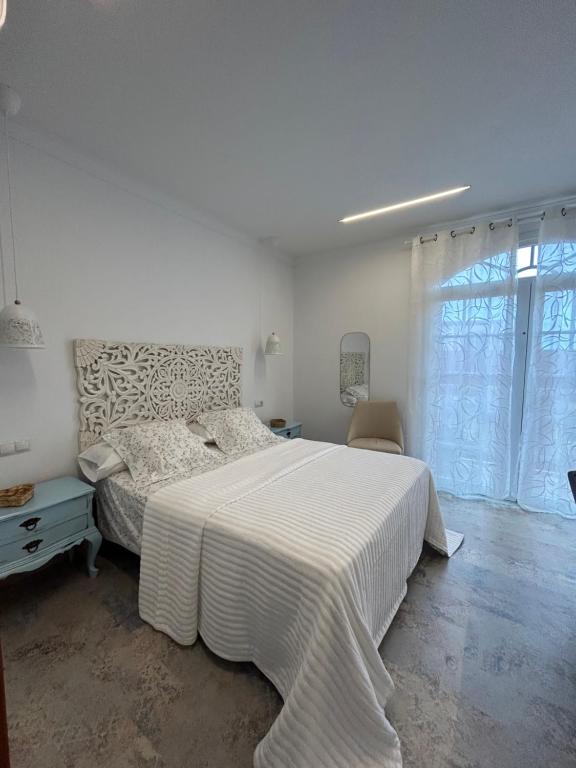 a white bedroom with a large bed and a window at Casa Daniella Vivienda B in Ingenio