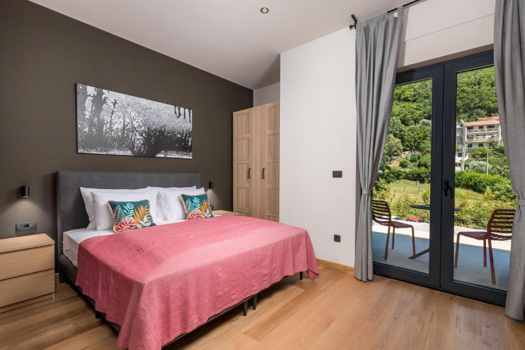 um quarto com uma cama com um cobertor rosa em PERUNIKA BED & BREAKFAST em Mošćenička Draga