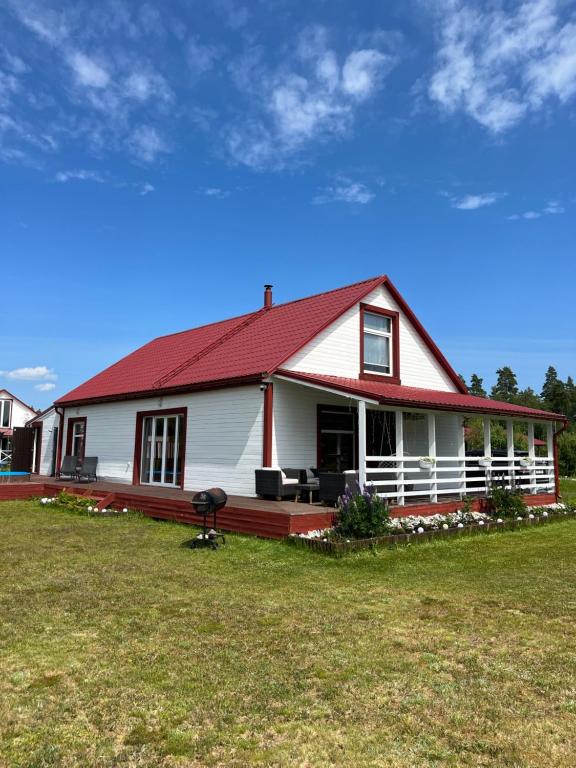 uma grande casa branca com um telhado vermelho em Robadeli Holiday House em Remniku