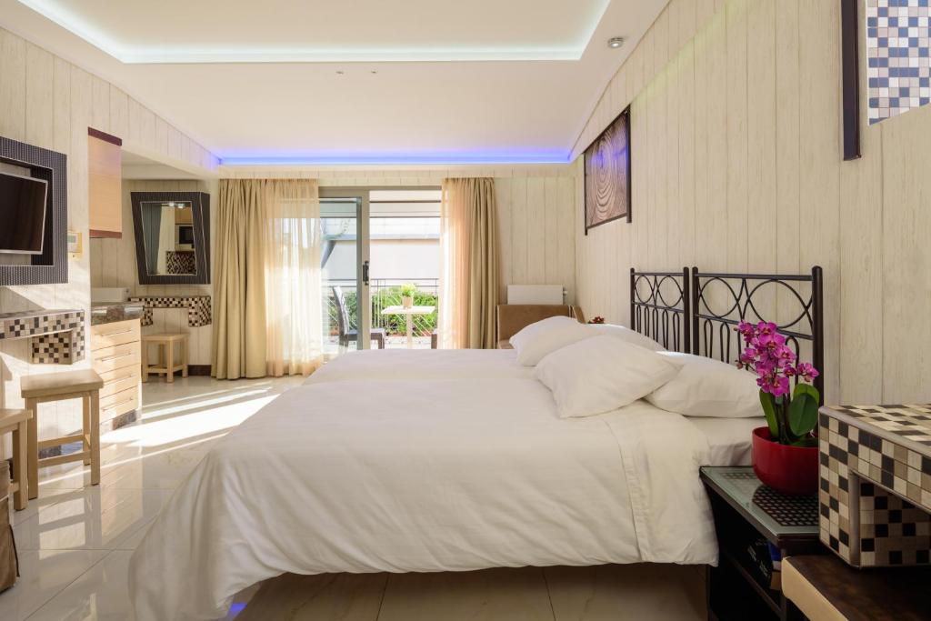 a bedroom with a large white bed and a kitchen at Lume Athens in Athens