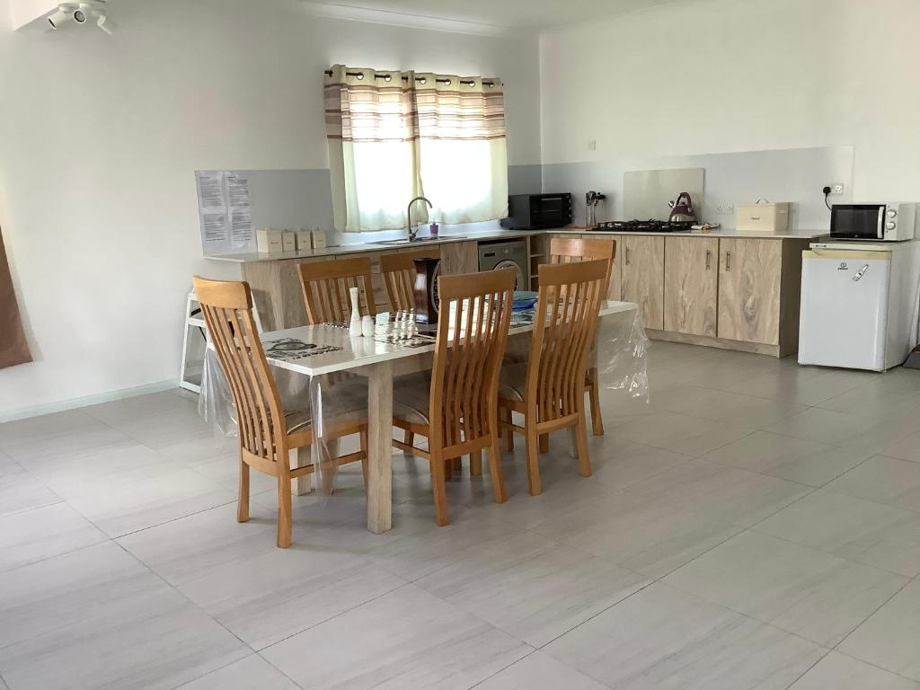 a dining room with a table and chairs in a kitchen at Cozy Place in Port Louis