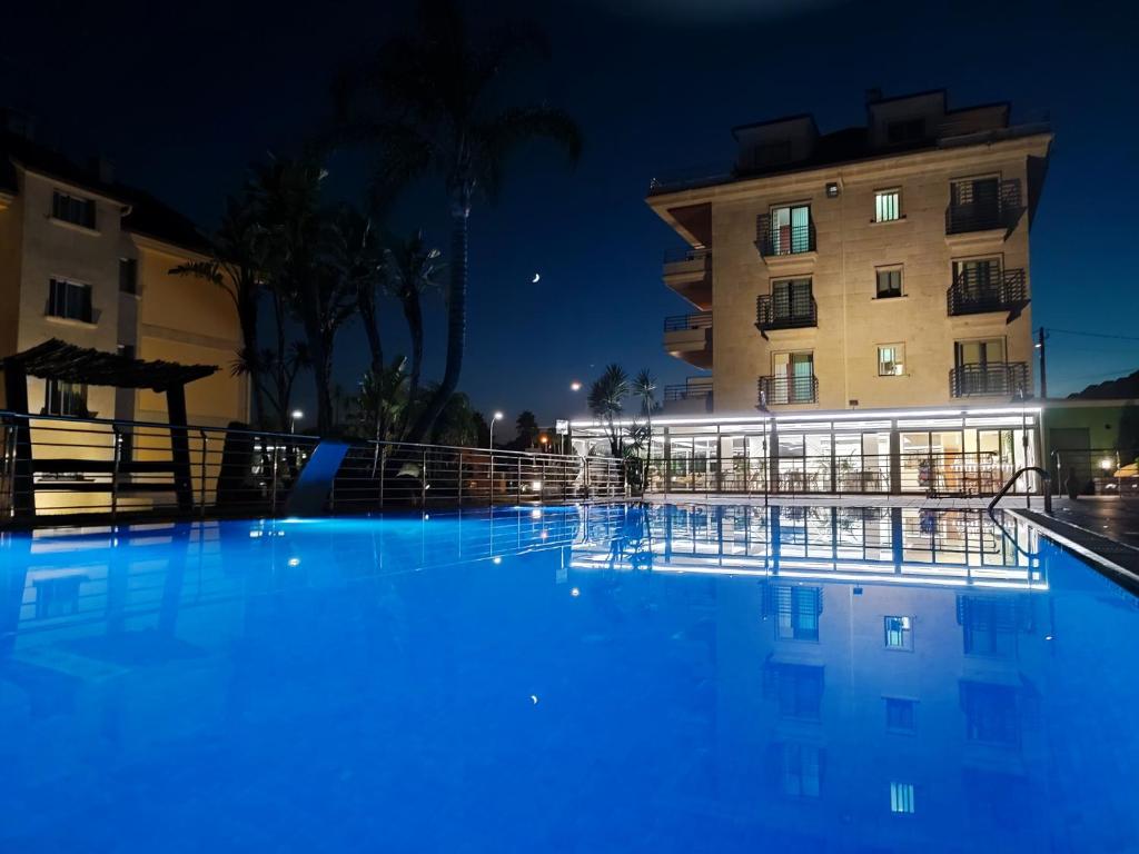 a large swimming pool in front of a building at night at Apartamentos Marsil in Montalvo