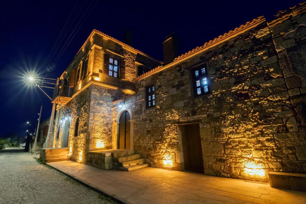 - un bâtiment en pierre avec des lumières allumées la nuit dans l'établissement Kocanli Kosku, à Dikili