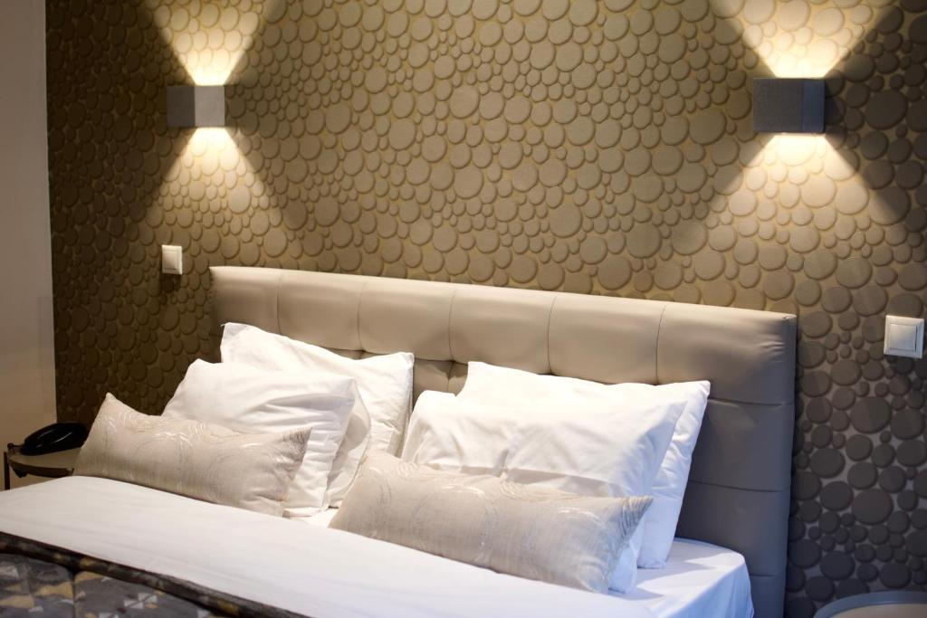 1 dormitorio con cama con almohadas y luces blancas en Minoa Athens Hotel, en Atenas