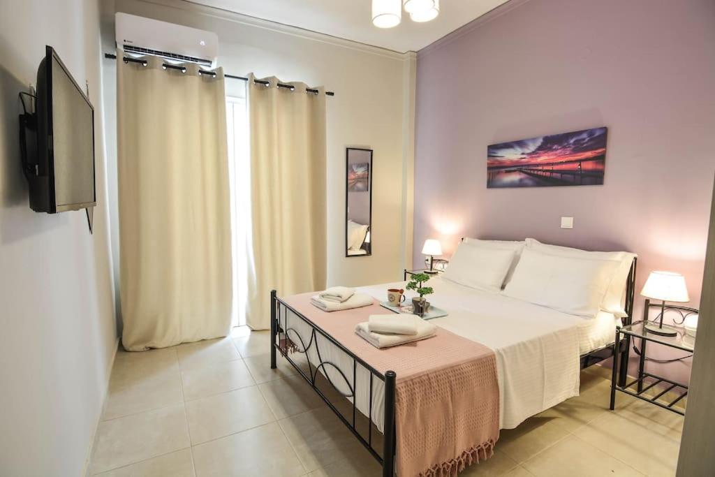 1 dormitorio con 1 cama y TV en Central Apartment en Xylokastro