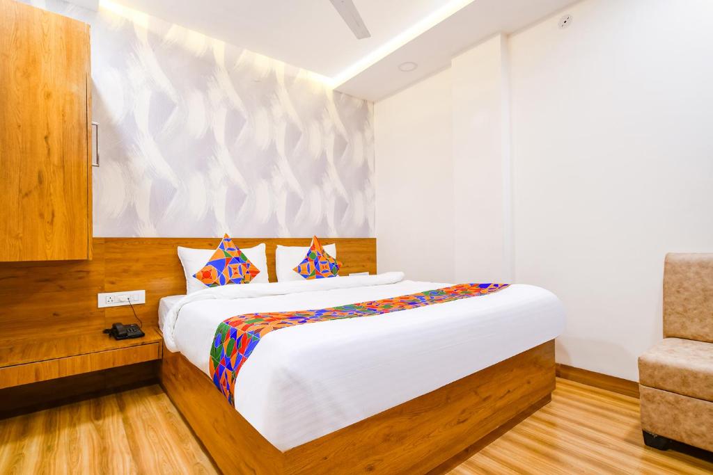 una camera con un grande letto e una sedia di FabHotel Woodlark Inn a Indore