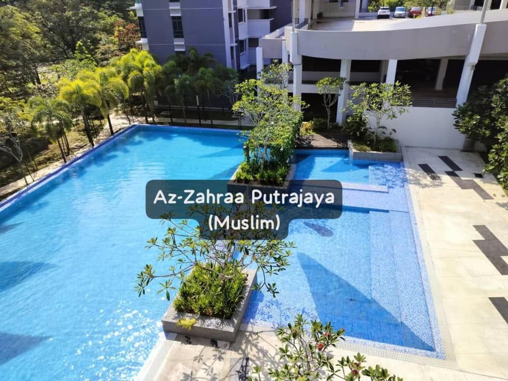 a blue swimming pool with a sign in front of a building at Az-Zahraa Putrajaya - Residences Presint 8 in Putrajaya