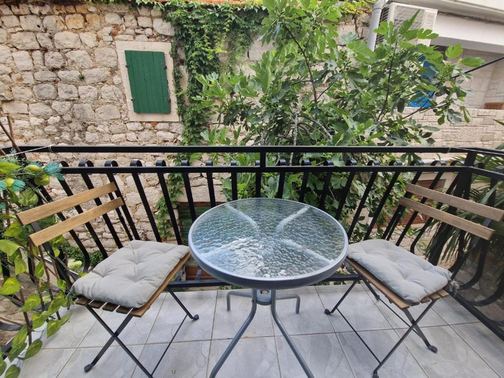 a glass table and two chairs on a balcony at Old town - Studio1 in Tribunj