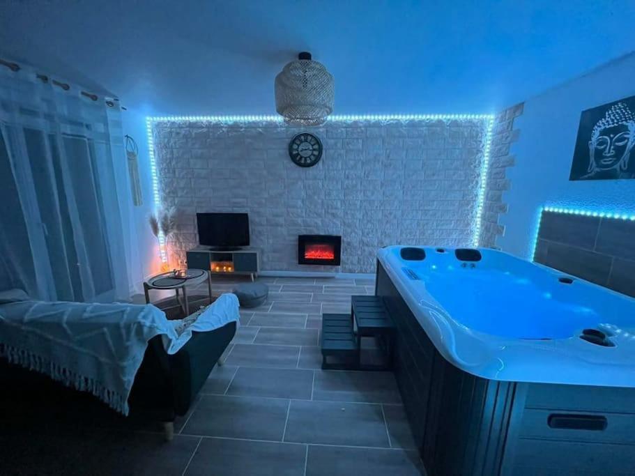 a large bathroom with a tub and a tv in it at Appartement jacuzzi mondonville in Mondonville