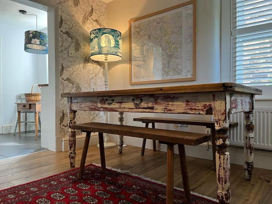 a wooden desk with a bench in a room at Dene Cottage in Stanton in Peak