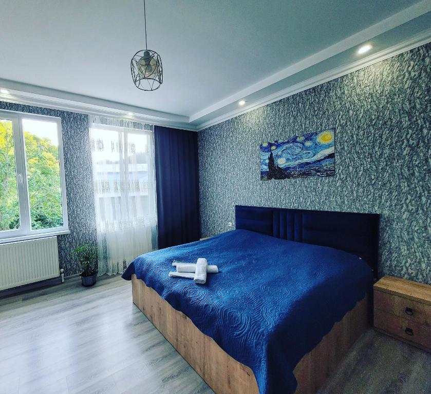 a bedroom with a blue bed with two white crosses on it at White House In Borjomi in Borjomi