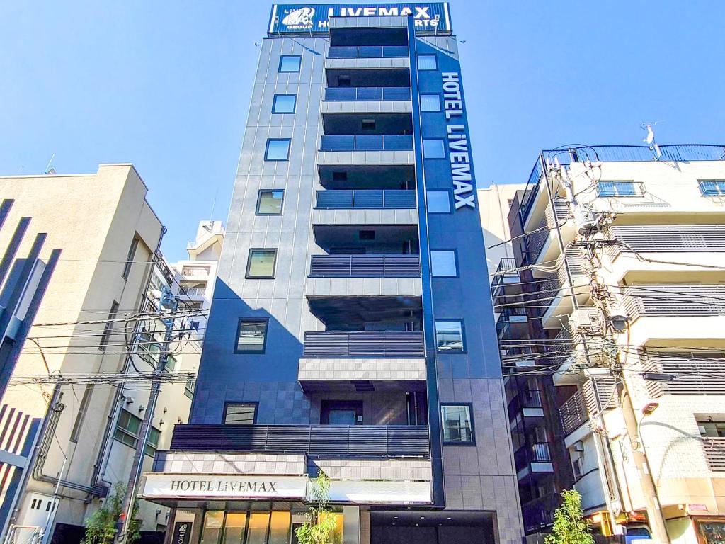 een hoog gebouw met een bord erop bij HOTEL LiVEMAX Akasaka GRANDE in Tokyo