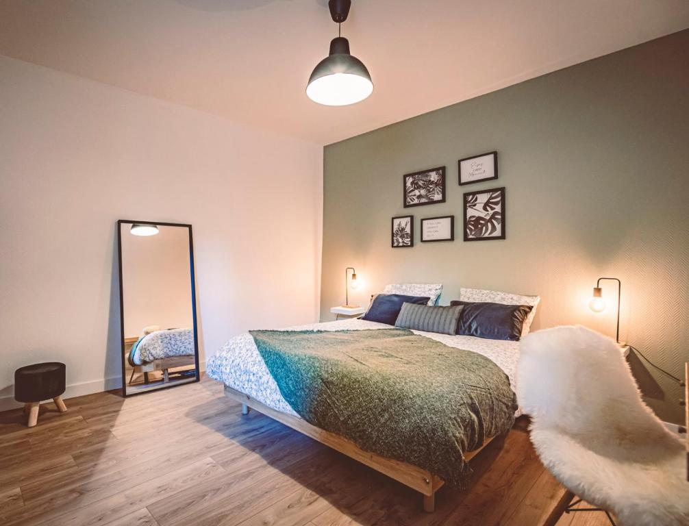 une chambre avec un grand lit et un miroir dans l'établissement La Suite - Paisible et à deux pas de la gare, à Reims
