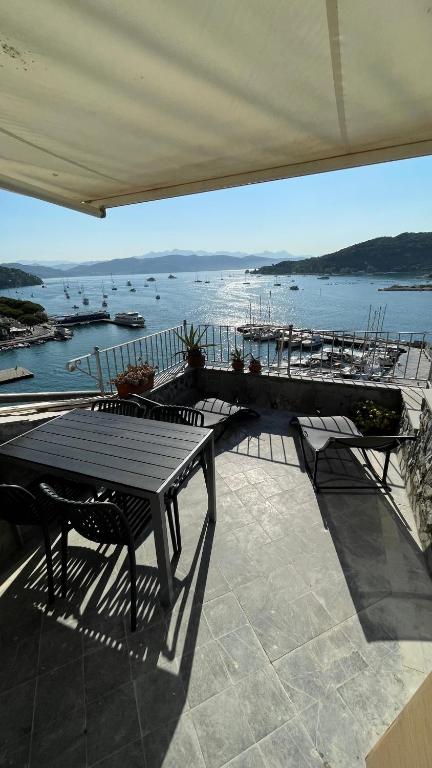 un patio con mesa y vistas al agua en Seafront rooftop flat w/ terrace en Portovenere