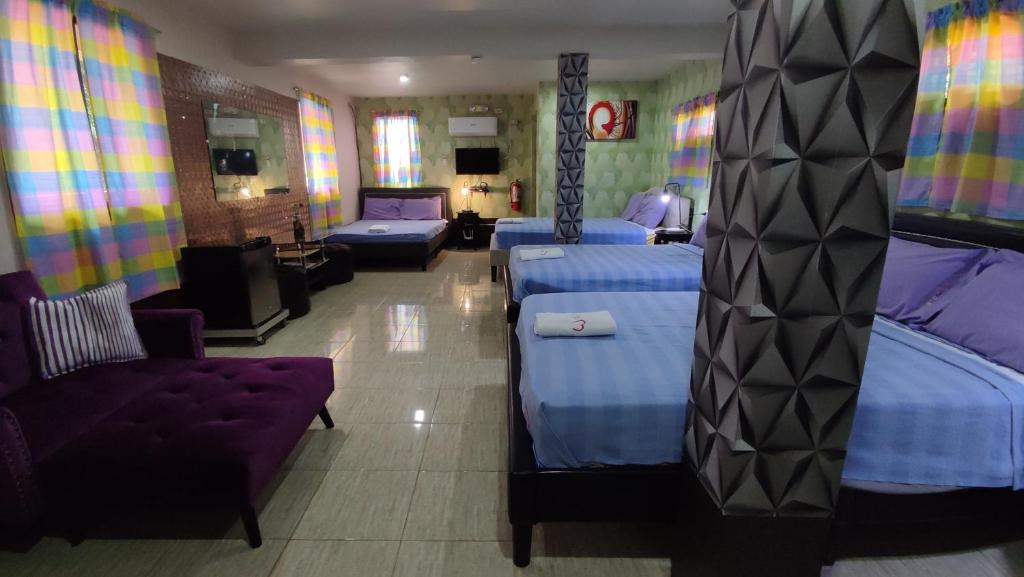 マリベレスにあるMargie's Place and Coffee Shop Inc.のベッド2台とソファが備わるホテルルームです。