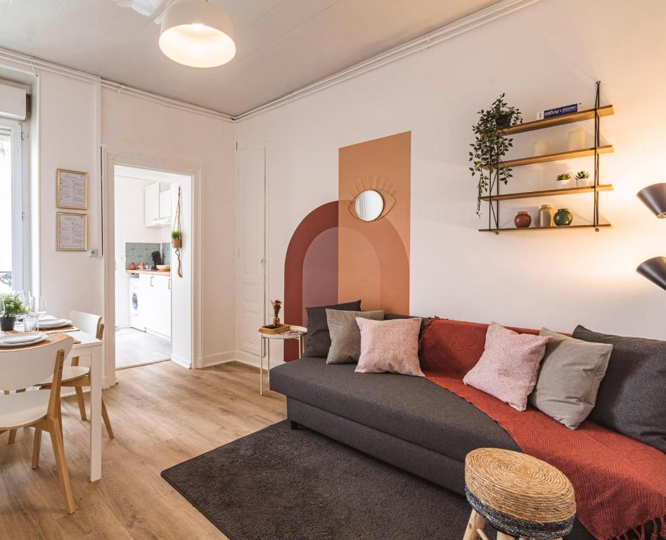 ein Wohnzimmer mit Sofa und Tisch in der Unterkunft Le Zola - charmant 2 chambres - centre gare in Reims