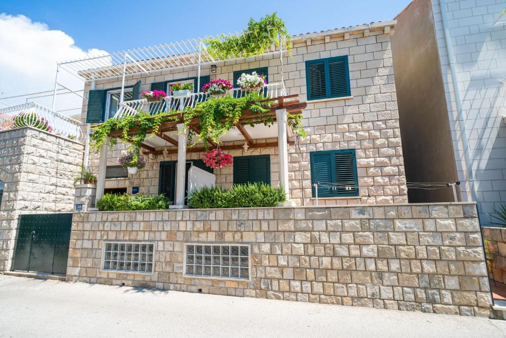 un edificio de ladrillo con un balcón con flores. en Apartments Villa Ivka, en Dubrovnik