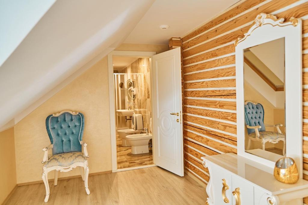 a bathroom with a blue chair and a mirror at Царська Долина in Neresnytsya