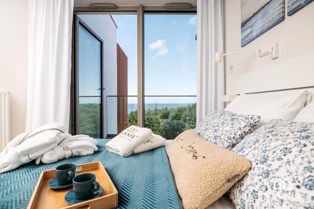 a bedroom with a bed with a large window at Apartament Premium Sea-Pinea Apartments Pobierowo in Pobierowo