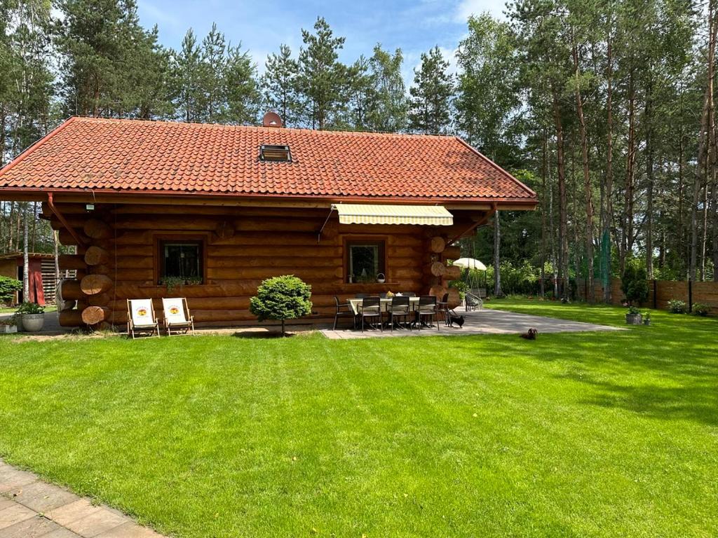 Cabaña de madera con mesa y sillas en un patio en Wikno Villa, en Nidzica