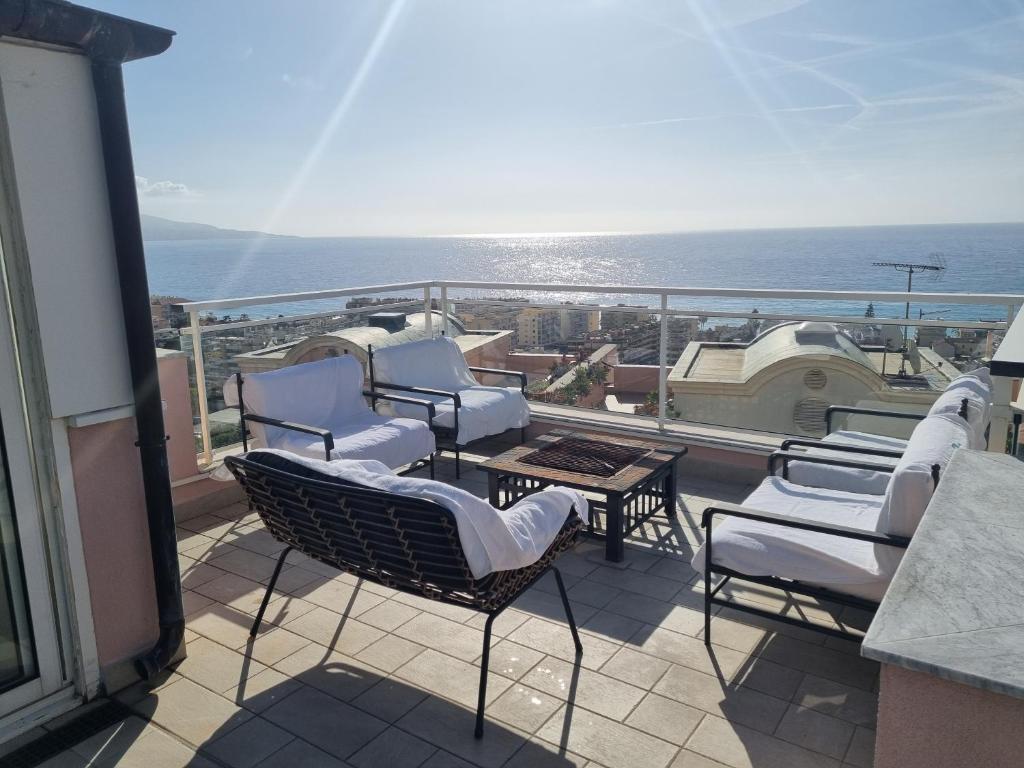 a balcony with chairs and a table and the ocean at Dernier étage d'une maison in Roquebrune-Cap-Martin