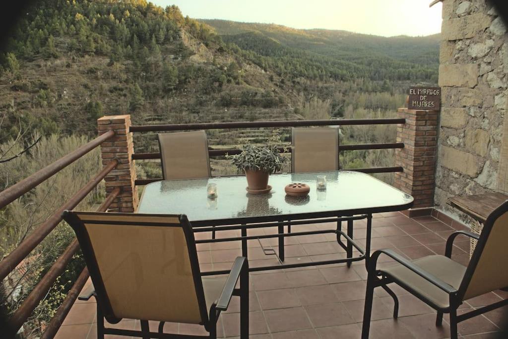 d'une table et de chaises sur un balcon avec vue. dans l'établissement Mirador de Mijares, à Los Pertegaces