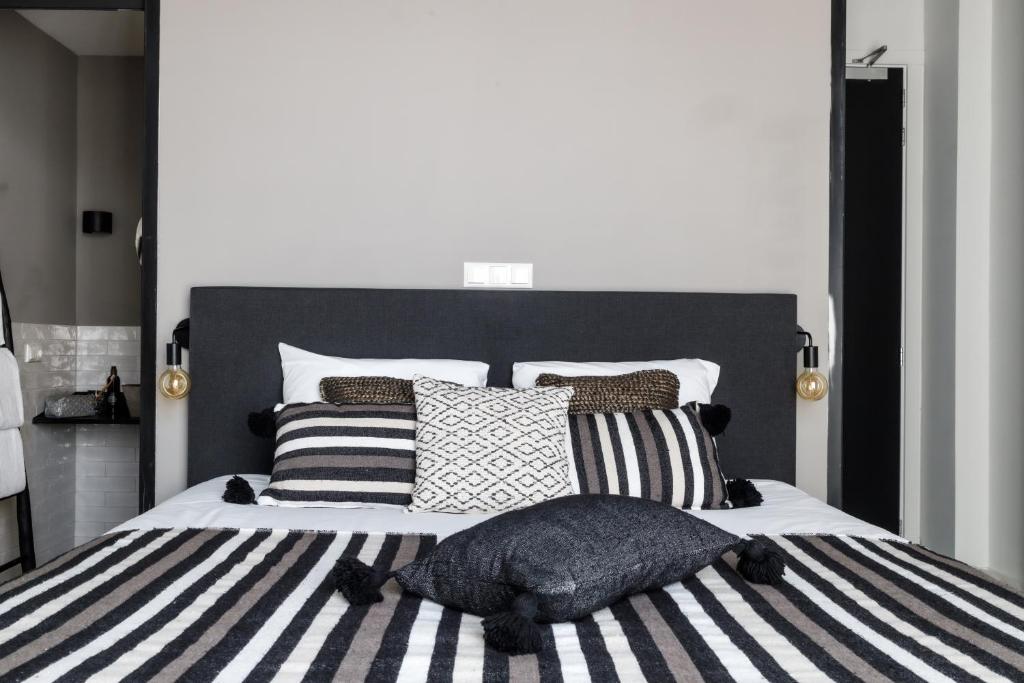 a bedroom with a large bed with black and white pillows at KASerne Boutique Hotel in Den Bosch